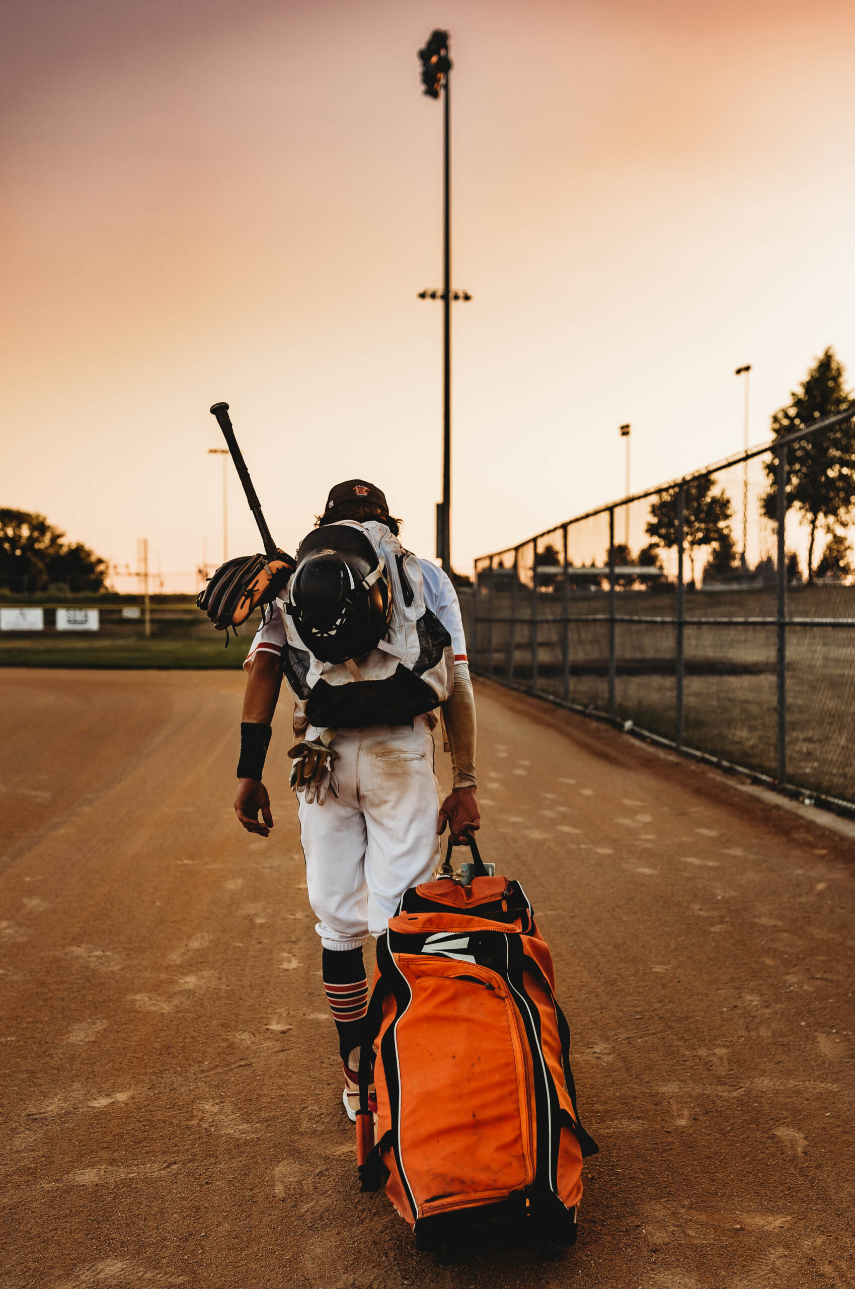 Baseball player walking home at the end of the game.